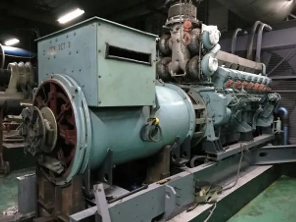 Large engine-driven alternator in an industrial generator room