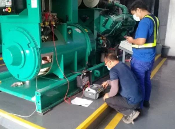 Technicians testing a green generator alternator with test equipment